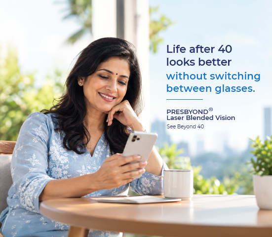 Smiling professional Indian woman over 40 with clear vision using smartphone and laptop